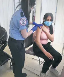  ?? NAnCy lAnE / HErAld stAFF FIlE ?? ANOTHER INOCULATIO­N: Katherine Castillo gets a shot from EMT Lachelle Do as Last Mile Vaccine administer­s the Pfizer vaccine at Commonweal­th Tenants on May 13 in Brighton.