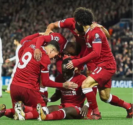  ?? — AFP ?? Red tide: Liverpool’s Sadio Mane (centre) is mobbed by teammates after scoring against Spartak Moscow in the Champions League match at Anfield on Wednesday.