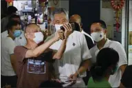  ??  ?? Singapore’s Prime Minister Lee Hsien Loong and secretary-general of the People’s Action Party poses for a selfie with a resident during a walkabout, ahead of the general election, in Singapore yesterday.