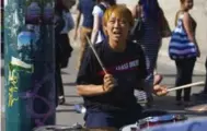  ??  ?? Drummer Yuta Sakai looks at the traffic on Spadina Ave. while playing a number on the corner.