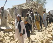  ?? Rahmatulla­h Nikzad / Associated Press ?? Residents stand near a damaged house in Ghazni after battles between Taliban and Afghan soldiers.