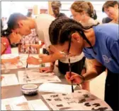  ?? ZHANG RUINAN / CHINA DAILY ?? Sheridan Cole, a 13-year-old student from MS 118 in the Bronx, New York, writes Chinese calligraph­y at China Open Day.