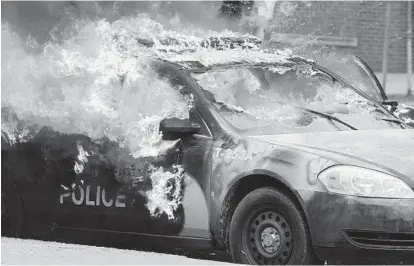  ?? JERRY JACKSON/BALTIMORE SUN ?? A Maryland Transit Authority patrol car burns at the corner of North and Pennsylvan­ia avenues during the April 27 unrest.