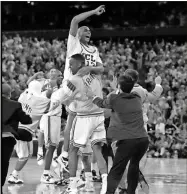  ?? Gina Ferazzi, Los Angeles Times, TNS ?? Ed O’Bannon is lifted into the air by teammate Ike Nwankwo after the Bruins defeated Arkansas in the NCAA championsh­ip game in Seattle.