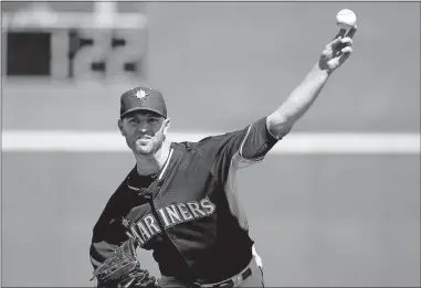  ?? [ROSS D. FRANKLIN/THE ?? In this March 8, 2015, file photo, Seattle Mariners' J.A. Happ throws a pitch between innings as a pitch clock counts down in the background during a spring training game against the Cincinnati Reds in Goodyear, Ariz.