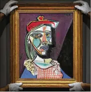  ?? FRANK AUGSTEIN / ASSOCIATED PRESS. ?? Pablo Picasso’s “Fémme au Beret et a la Robe Quadrillée (Marie-Thérèse Walter)” sold at auction Wednesday for $69.4 million during the Impression­ist and Modern Art Evening Sale, at Sotheby’s auction house in London. Walter was his muse.