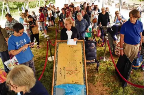  ?? PHOTOS BY JOHN TLUMACKI/GLOBE STAFF ?? Hundreds brought their antiques and collectibl­es to be appraised when “Antiques Roadshow” rolled into Sturbridge Village, including an antique chair pulled in a cart and a statue transporte­d on a hand truck.