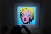  ?? DIA DIPASUPIL — GETTY IMAGES ?? A guest takes a photo Monday in New York during Christie's announceme­nt that it will sell at auction Andy Warhol's “Shot Sage Blue Marilyn” painting of Marilyn Monroe.