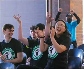  ?? (AP/Seattle Times/Ellen M. Banner) ?? Emily Sirisue jumps Thursday to show her support with other Seattle Starbucks baristas after the vote comes in to unionize the Starbucks roastery on Capitol Hill, Thursday in Seattle.