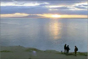  ?? The Associated Press ?? Visitors to Point Woronzof Park watch the sun set over Cook Inlet and Mount Susitna, also known as Sleeping Lady, in 2013, in Anchorage, Alaska.