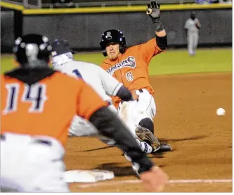  ??  ?? Dragons manager Luis Bolivar signals T.J. Friedl to slide into third base with an RBI triple in the second inning of the second game Friday against the Lake County Captains. MARC PENDLETON / STAFF