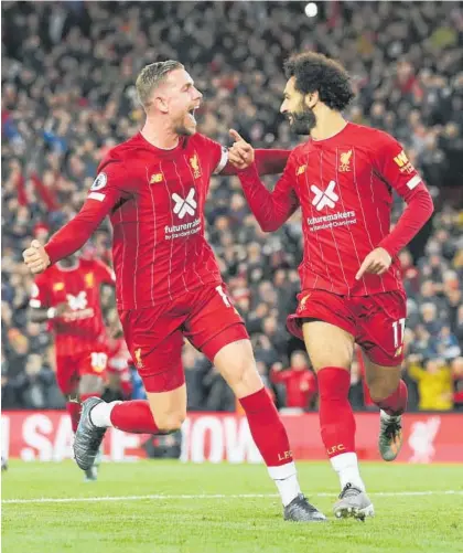  ?? Photo / AP ?? Liverpool’s Mohamed Salah (right) and Jordan Henderson celebrate their side’s second goal against Tottenham Hotspur.