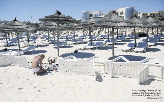  ?? DARKO VOJINOVIC ?? A woman lays flowers at the scene of the terrorist attack in Sousse, Tunisia, in 2015