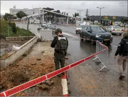  ?? JALAA MAREY – GETTY IMAGES ?? An Israeli police officer inspects the impact crater left by a rocket fired from southern Lebanon where it landed near the entrance of a hospital in Safed on Wednesday.