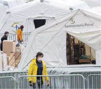  ??  ?? A Samaritan’s Purse crew and medical personnel work on preparing to open a 68-bed emergency field hospital specially equipped with a respirator­y unit in New York’s Central Park.