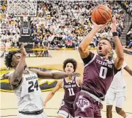  ?? Jay Biggerstaf­f/Getty Images ?? Texas A&M’s Dexter Dennis shoots as Missouri’s Kobe Brown, left, defends in Saturday’s victory.