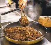  ?? ?? Raw spaghetti is toasted in the pan with garlic and chiles before it is cooked with tomato sauce.