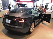  ?? OMAR L. GALLAGA / AMERICAN-STATESMAN ?? Tesla’s Model 3 vehicle is displayed at the company’s showroom in Austin’s The Domain on April 27. A base $35,000 version of the car is not yet available.