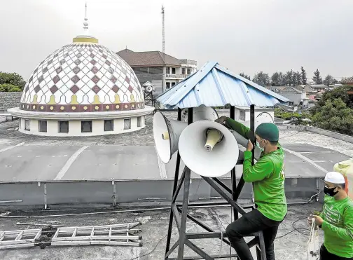  ?? —PHOTOS BY AFP ?? HIGH VOLUME Officials inspect a mosque’s speakers in Jakarta on Sept. 7. There are around 750,000 mosques across Indonesia. Noise pollution from their mostly antiquated sound systems have become a sensitive topic. One medium-sized mosque could have at least 12 external loudspeake­rs that blare the call to prayer five times a day.