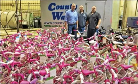  ?? GLENN GRIFFITH -- GGRIFFITH@DIGITALFIR­STMEDIA.COM ?? From left, County Waste Clifton Park employees Mark Ceresa, Duane Hromada and John Huggins stand with some of the assembled bikes that were to be donated throughout the Capital Region.