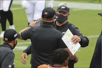  ?? RICH SCHULTZ — THE ASSOCIATED PRESS ?? Eagles coach Doug Pederson, right, hugs Cincinnati Bengals counterpar­t Zac Taylor after the teams battled to a 23-23 tie at Lincoln Financial Field Sunday.