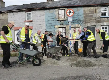  ??  ?? Local residents and friends filling in the potholes on Ship Street.