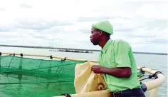  ?? ?? A worker at Zhovhe Farm feeds fish that are part of a Government fisheries project