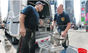  ??  ?? New York City Police Department farriers Marcus Martinez Jr., left, and Thomas Nolan confer at their mobile workshop, as they prepare to shoe a department horse in Times Square.