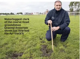  ??  ?? Waterlogge­d: clerk of the course-head groundsman Graeme Anderson shows just how bad the Ayr track is