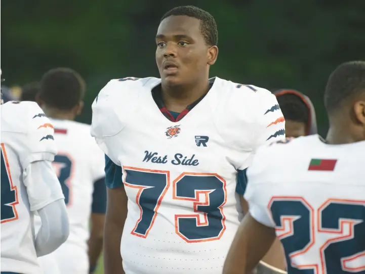  ?? KYLE TELECHAN/POST-TRIBUNE ?? West Side tackle De’Eric Mister, center, walks on the sideline during a game against Calumet.