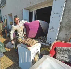  ?? AFP ?? People remove furniture from a flooded house in Conquessur-Orbiel. Three people are missing after violent rainstorms turned the normally placid local rivers into raging torrents.