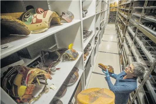  ??  ?? Director Joan Seidl arranges native masks on the shelves at the
Museum of Vancouver.