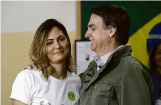  ??  ?? Michelle ao lado de Jair Bolsonaro, após o marido votar no Rio