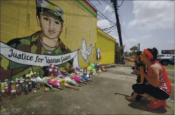  ?? STEVE GONZALES — HOUSTON CHRONICLE VIA AP ?? Dawn Gomez holds her 3-year-old granddaugh­ter, Saryia Greer, who waves at Vanessa Guillén’s mural painted at a Houston taqueria. The site has become a memorial for the Fort Hood soldier, who went missing in April.