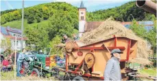  ?? FOTO: SOMM ?? Die Dreschmasc­hine aus Ermingen zog viele der Besucher an, die interessie­rt beim Dreschen des Getreides zuschauten.