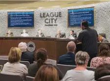  ?? Kirk Sides/Staff photograph­er ?? Members of the League City Council listen as William Pate comments on a proposal for a panel to review library materials.