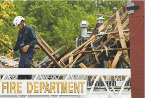  ?? RJ Sangosti, The Denver Post ?? Emergency crews work at the pile of rubble containing bricks, wooden beams and debris at the corner of the 300 block of Santa Fe Drive in Denver on Tuesday afternoon.