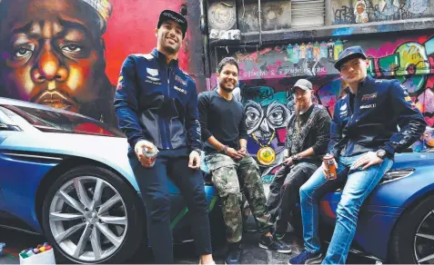  ?? Picture: MARK THOMPSON/GETTY ?? SPRAY DAY: Daniel Ricciardo of Australia and Red Bull Racing and Max Verstappen of Netherland­s and Red Bull Racing pose for a photo with street artists Julian Clavijo and Bryan Itch at an Aston Martin Red Bull Racing media call.