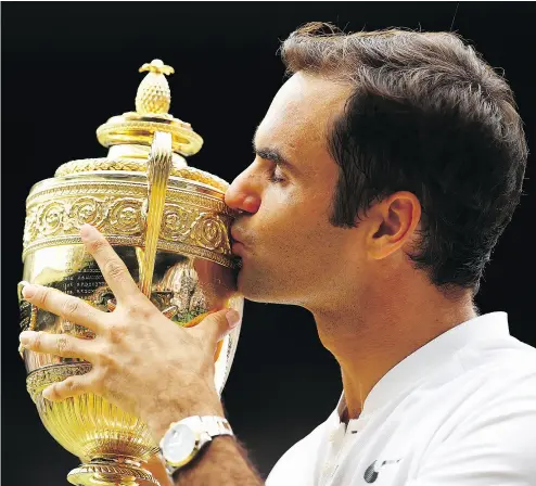  ?? CLIVE BRUNSKILL / GETTY IMAGES ?? Switzerlan­d’s Roger Federer extended his Grand Slam record with a 19th men’s singles title Sunday in London, sweeping past all of competitor­s at Wimbledon without dropping a set over the course of the tournament.