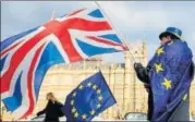  ?? AFP ?? An antibrexit demonstrat­or waves a Union Jack alongside a EU flag outside the Houses of Parliament in London.