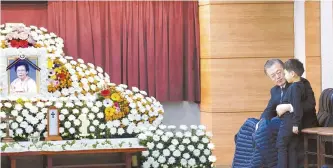  ?? Yonhap ?? President Moon Jae-in holds his grandson at a memorial altar for his late mother Kang Han-ok at the Namcheon Cathedral of the Holy Cross in Busan, Wednesday.