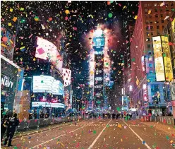  ?? Getty Images/TNS ?? ■ Confetti fills the air on a mostly empty Times Square on New Year’s Eve in New York City. Due to the coronaviru­s outbreak, Times Square was closed to all but a few revelers.