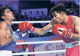  ?? V. V. KRISHNAN ?? Body blow: Mohammed Hussamuddi­n (right) punches Satish Kumar during a feather-weight clash at the National Games in Gandhinaga­r. En route to his gold medal, Hussamuddi­n beat National champion Rohit Mor and World youth champion Sachin Siwach Junior.