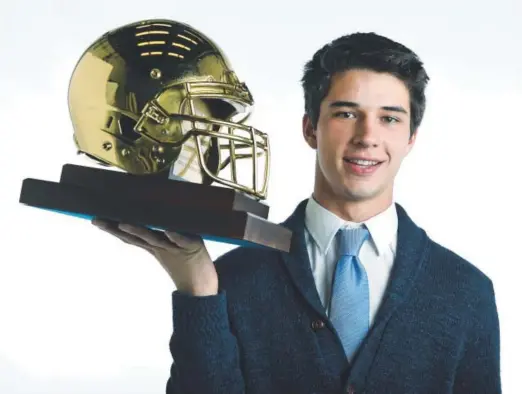  ?? Andy Cross, The Denver Post ?? Valor Christian quarterbac­k Dylan McCaffrey holds The Denver Post’s Gold Helmet he was awarded Thursday.