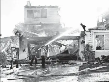  ?? MARCIO JOSE SANCHEZ/AP ?? Firefighte­rs try to put out a residence fire Friday in Santa Clarita, which is about 35 miles northwest of Los Angeles.