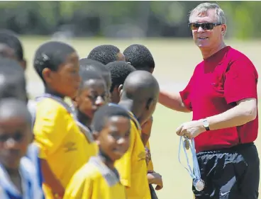  ?? Images ?? The last dictator: Sir Alex Ferguson hands medals to young footballer­s at a football clinic in Vanderbijl­park during a visit in 2002. The former Manchester United manager is recuperati­ng in hospital after surgery for a brain haemorrhag­e./Gallo