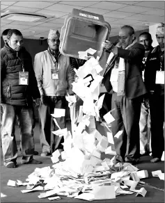 ??  ?? File photo shows an official from the election commission pouring the ballot papers from the box, as officials start counting the votes, a day after the parliament­ary and provincial elections in Kathmandu, Nepal. — Reuters photo