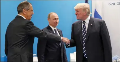  ?? The Associated Press ?? FOREIGN MINISTER: U.S. President Donald Trump, right, greets Russian Foreign Minister Sergey Lavrov, left, prior his talks with Russian President Vladimir Putin, center, during the G20 summit Friday in Hamburg Germany,.