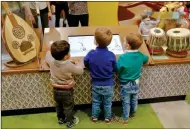  ?? ASSOCIATED PRESS ?? IN THIS MARCH 31 PHOTO, youngsters interact with a display of musical instrument­s at Children’s Museum of Manhattan, during the exhibition “America to Zanzibar: Muslim Cultures Near and Far,” in New York. The exhibit runs through December.