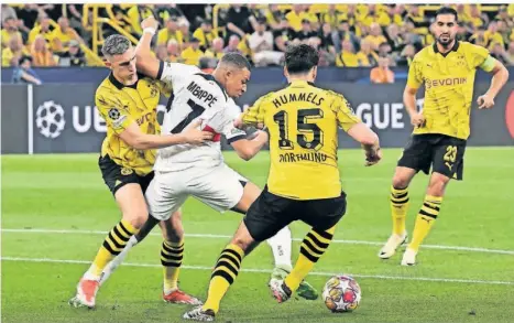  ?? FOTO: FEDERICO GAMBARINI/DPA ?? Dortmunds Nico Schlotterb­eck (l.) und Mats Hummels (r.) verteidigt­en nicht nur gegen PSG-Spieler Kylian Mbappé konsequent.